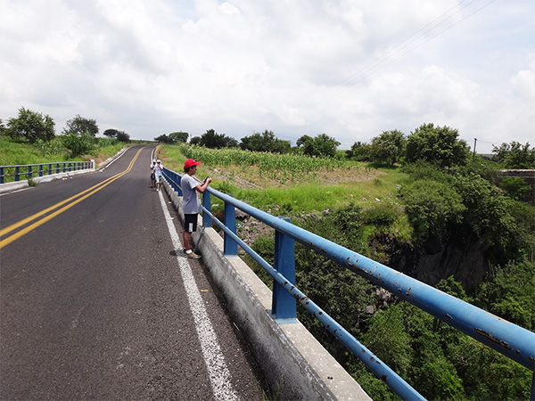 Senderista en el puente nuevo de Tecajec, carretera rural pavimentada, municipio Yecapixtal, Estado de Morelos